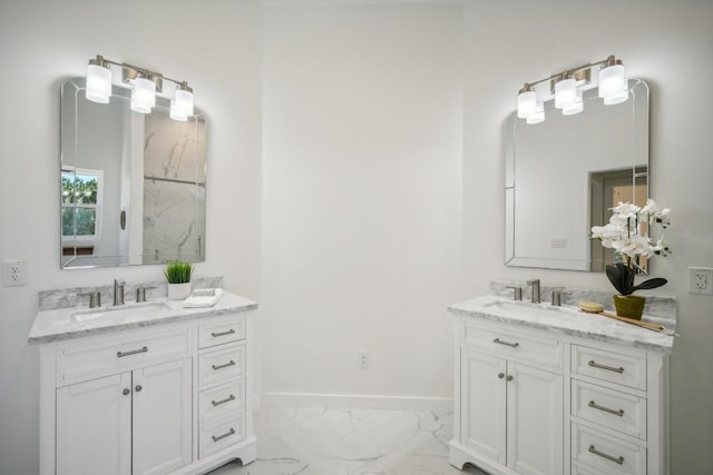 bathroom featuring two vanities, baseboards, marble finish floor, and a sink