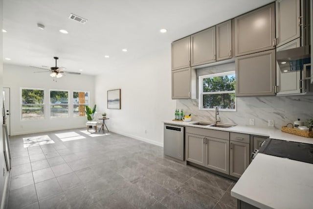 kitchen with visible vents, a sink, gray cabinetry, dishwasher, and tasteful backsplash