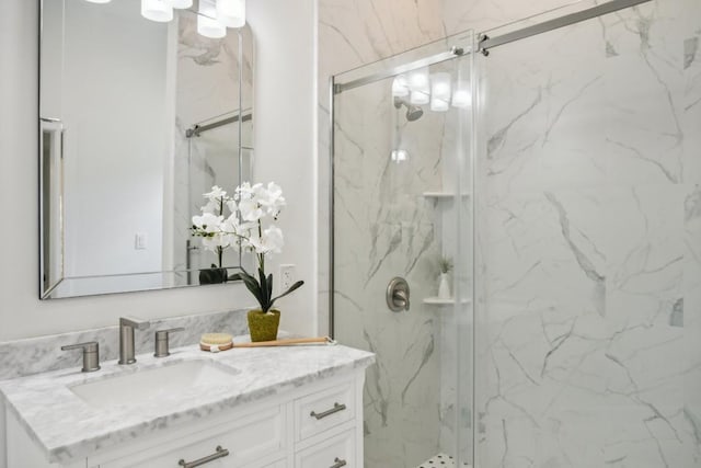 bathroom featuring a marble finish shower and vanity