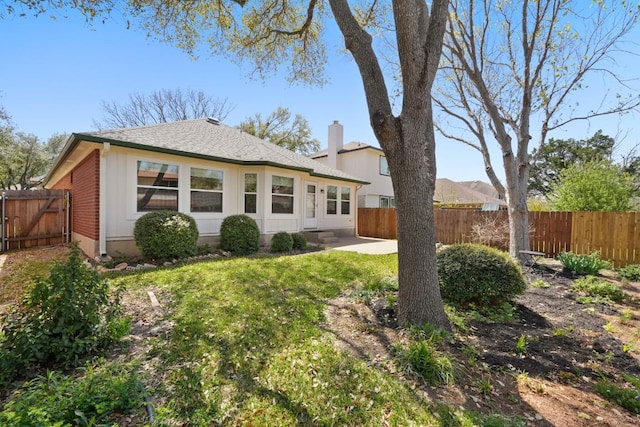 9408 Notches Dr, Austin, TX 78748 - back of house with a patio area, a fenced backyard, a gate, a lawn, and a chimney