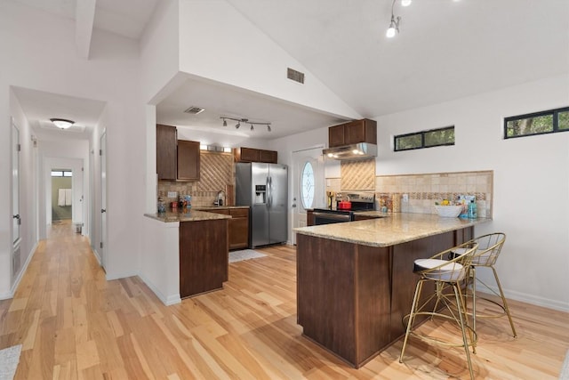 4004 Highland Dr, Austin, TX 78734 - kitchen featuring appliances with stainless steel finishes, a peninsula, track lighting, under cabinet range hood, and light wood finished floors