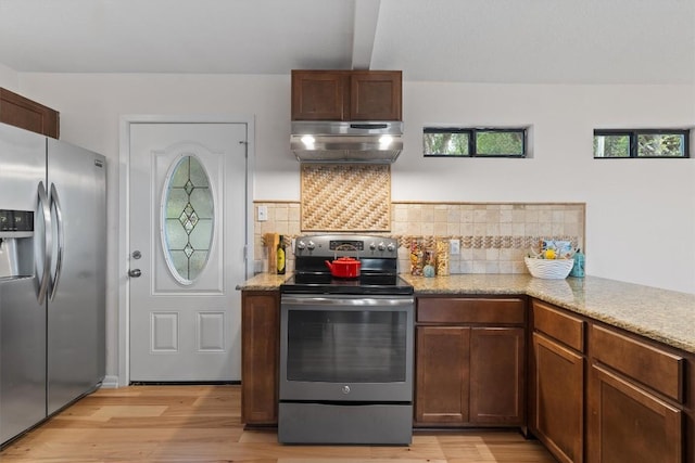 4004 Highland Dr, Austin, TX 78734 - kitchen with stainless steel appliances, exhaust hood, light wood-style flooring, and tasteful backsplash