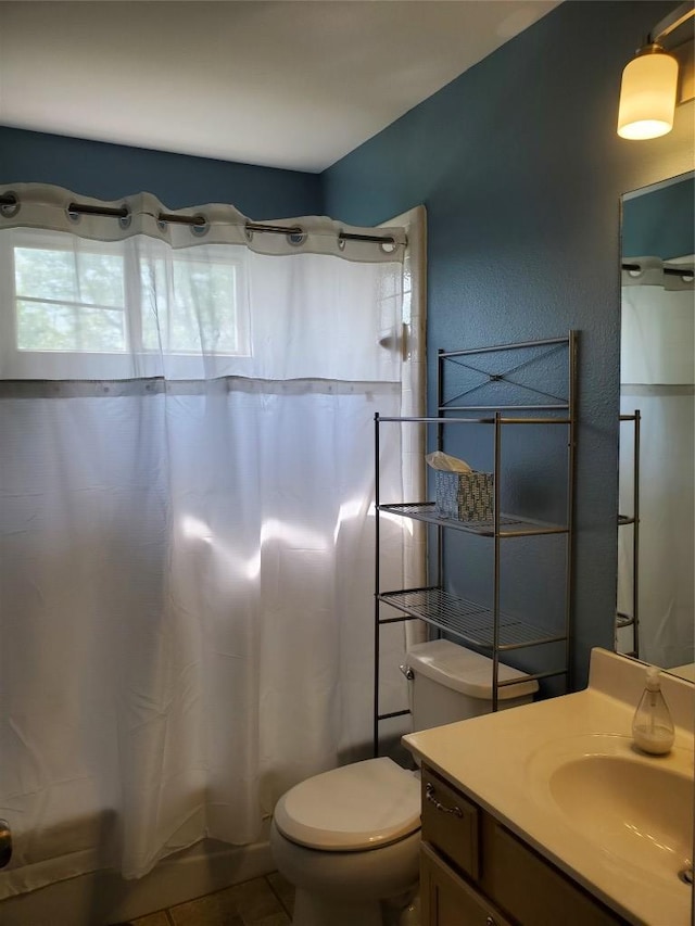 bathroom with shower / tub combo, toilet, vanity, and a wealth of natural light