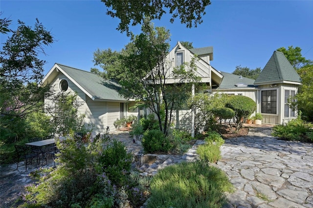 167 N Tumbleweed Trl, Austin, TX 78733 - back of house featuring a shingled roof and a patio