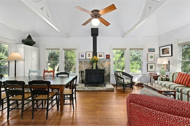 167 N Tumbleweed Trl, Austin, TX 78733 - living room featuring a healthy amount of sunlight, a wood stove, ceiling fan, wood-type flooring, and beamed ceiling