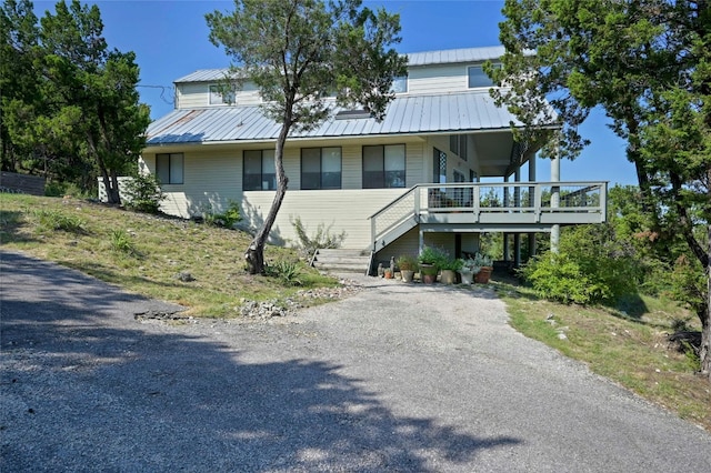 167 N Tumbleweed Trl, Austin, TX 78733 - view of front of house featuring stairs, a porch, driveway, and metal roof