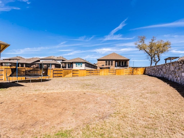 110 Pigeon River Rd, Kyle, TX 78640 - fenced backyard with a trampoline and a residential view