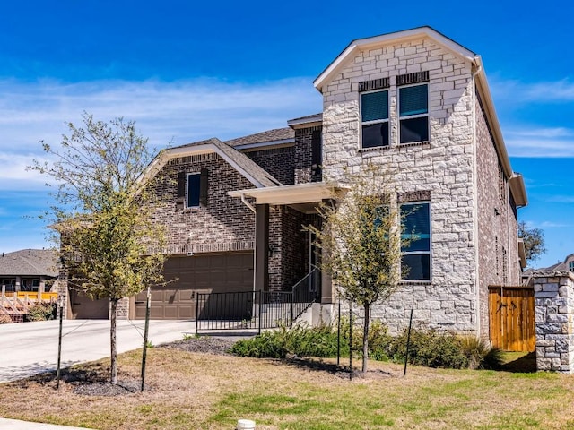 110 Pigeon River Rd, Kyle, TX 78640 - view of front facade with a garage, driveway, stone siding, and brick siding
