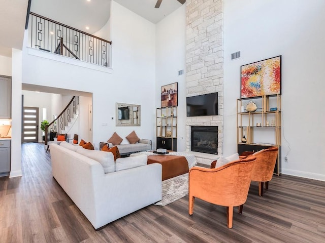 110 Pigeon River Rd, Kyle, TX 78640 - living room featuring a high ceiling, dark wood finished floors, a fireplace, stairs, and ceiling fan