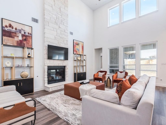 110 Pigeon River Rd, Kyle, TX 78640 - living room with a towering ceiling, baseboards, a fireplace, dark wood-type flooring, and a ceiling fan