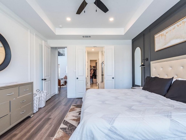 110 Pigeon River Rd, Kyle, TX 78640 - bedroom featuring dark wood finished floors, a tray ceiling, ceiling fan, and recessed lighting