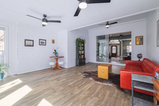 30228 Saint Andrews Dr, Georgetown, TX 78628 - living area featuring brick wall, wood finished floors, and a ceiling fan