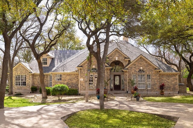 30228 Saint Andrews Dr, Georgetown, TX 78628 - view of front of home featuring brick siding, a front yard, and a chimney