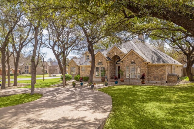 30228 Saint Andrews Dr, Georgetown, TX 78628 - view of front of home featuring a front lawn, brick siding, and stone siding