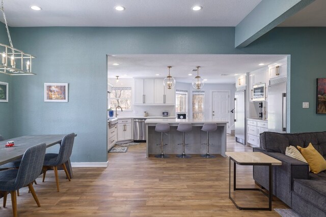 30228 Saint Andrews Dr, Georgetown, TX 78628 - living area with wood finished floors, a chandelier, and recessed lighting