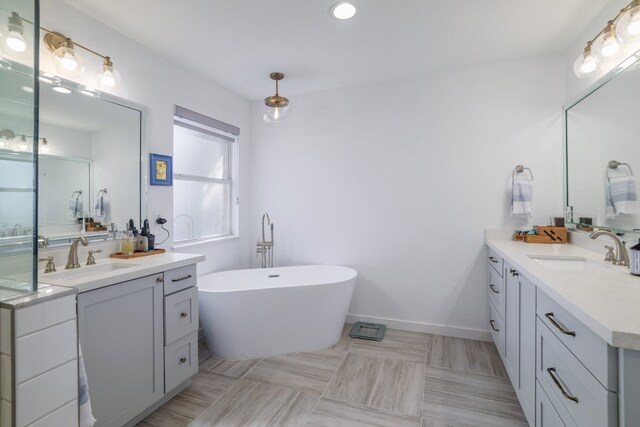30228 Saint Andrews Dr, Georgetown, TX 78628 - full bathroom featuring two vanities, a soaking tub, and recessed lighting
