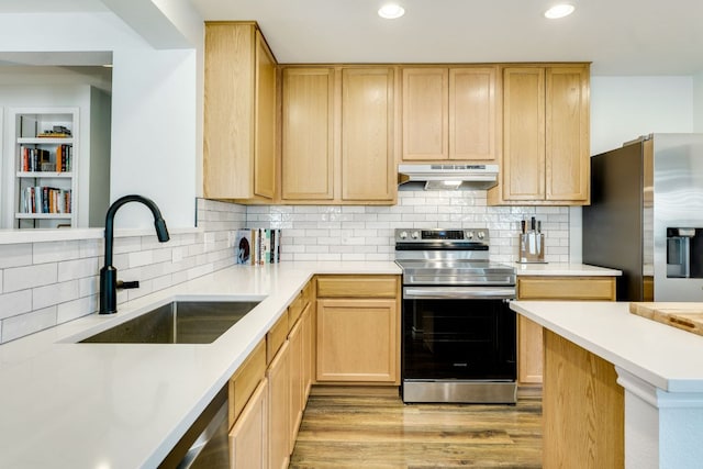 837 Watson Way, Pflugerville, TX 78660 - kitchen with appliances with stainless steel finishes, under cabinet range hood, light brown cabinetry, light wood-style flooring, and light countertops