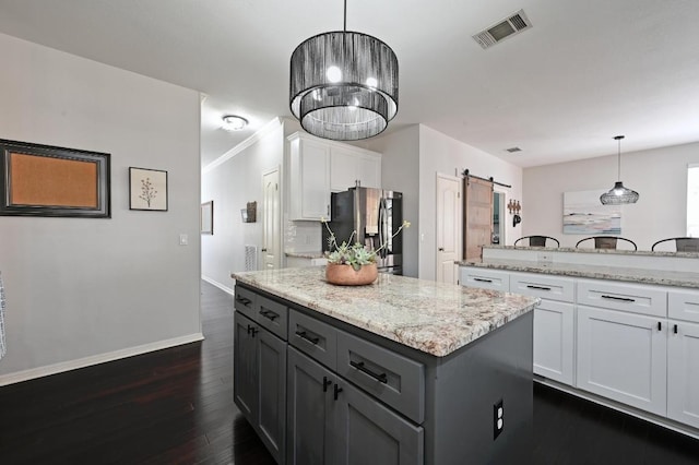 kitchen with a barn door, baseboards, visible vents, white cabinetry, and stainless steel fridge with ice dispenser