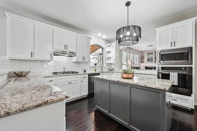 kitchen featuring stainless steel appliances, a sink, backsplash, white cabinetry, and under cabinet range hood