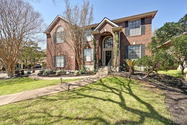 traditional-style house with brick siding and a front lawn