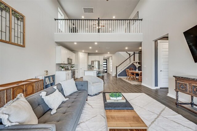 329 Peace Pipe Way, Georgetown, TX 78628 - living area featuring stairs, a towering ceiling, dark wood-style floors, recessed lighting, and baseboards