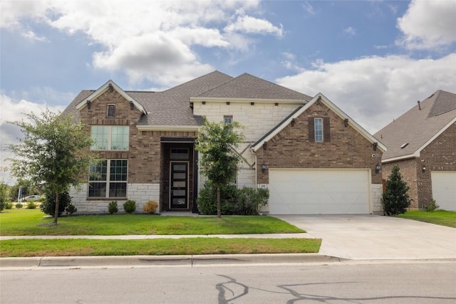 896 Spinnaker Loop, Kyle, TX 78640 - view of front facade featuring driveway, brick siding, a front yard, and stone siding