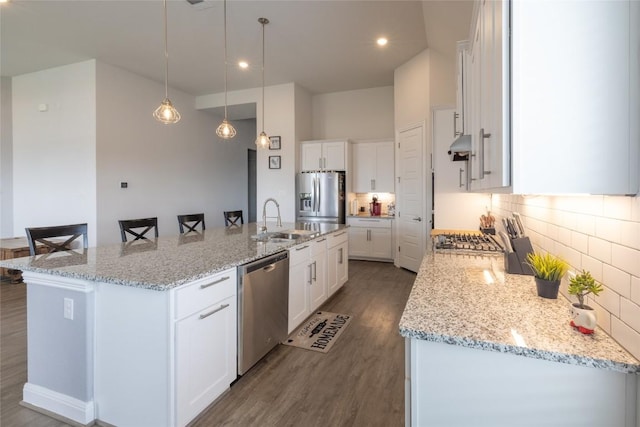 896 Spinnaker Loop, Kyle, TX 78640 - kitchen with stainless steel appliances, dark wood finished floors, a large island with sink, decorative backsplash, and white cabinets