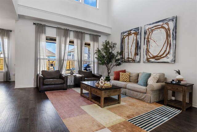 living area featuring wood-type flooring, baseboards, and a healthy amount of sunlight