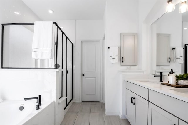 full bath with double vanity, a bath, a stall shower, a sink, and tile patterned floors