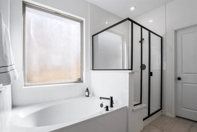 full bathroom with tile patterned flooring, a bath, and a stall shower