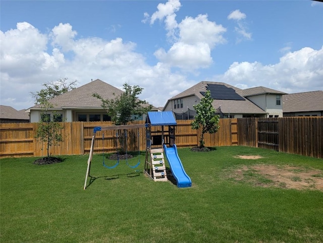 view of playground featuring a yard and a fenced backyard