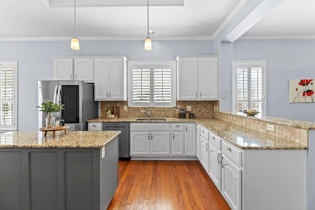 100 Blacksmiths Cir, Georgetown, TX 78633 - kitchen with stainless steel appliances, white cabinetry, a peninsula, ornamental molding, and backsplash