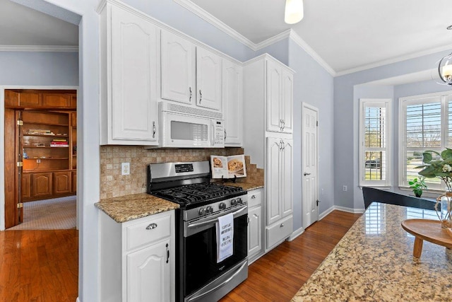 100 Blacksmiths Cir, Georgetown, TX 78633 - kitchen with gas stove, white microwave, white cabinets, dark wood finished floors, and crown molding