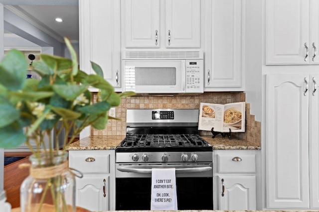 100 Blacksmiths Cir, Georgetown, TX 78633 - kitchen with white microwave, stainless steel gas range oven, white cabinetry, backsplash, and crown molding