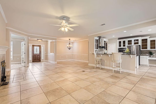 407 Breezeway Ln, Georgetown, TX 78633 - unfurnished living room featuring recessed lighting, a decorative wall, light tile patterned floors, ornamental molding, and ceiling fan with notable chandelier