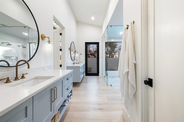 5805 Twin Peaks Trce, Austin, TX 78738 - full bathroom featuring a shower stall, two vanities, wood finished floors, and recessed lighting