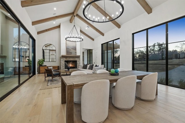 5805 Twin Peaks Trce, Austin, TX 78738 - dining area with a chandelier, a warm lit fireplace, beam ceiling, light wood-style flooring, and healthy amount of natural light