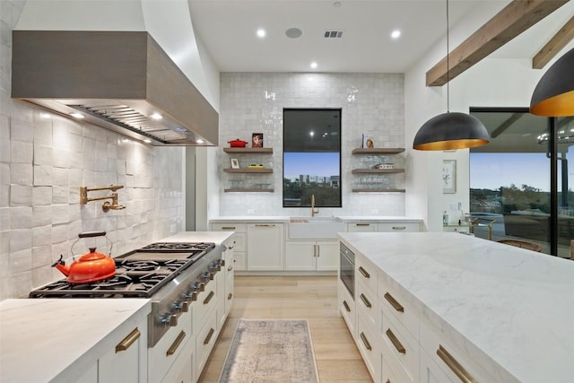 5805 Twin Peaks Trce, Austin, TX 78738 - kitchen featuring open shelves, wall chimney exhaust hood, a sink, stainless steel gas stovetop, and light stone countertops