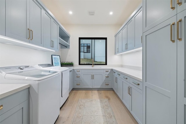 5805 Twin Peaks Trce, Austin, TX 78738 - laundry area featuring cabinet space, washing machine and dryer, light wood-style flooring, and recessed lighting
