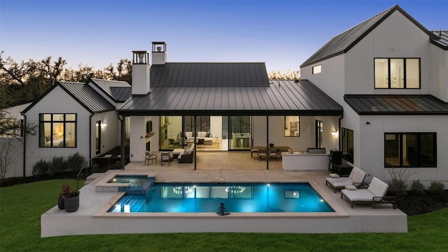 5805 Twin Peaks Trce, Austin, TX 78738 - back of house at dusk featuring a standing seam roof, an outdoor living space, and metal roof