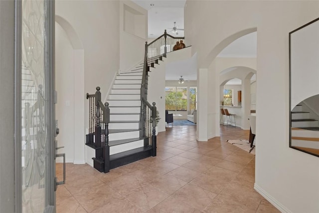 4004 Buckhaven Cv, Cedar Park, TX 78613 - entryway featuring a ceiling fan, stairs, arched walkways, baseboards, and a towering ceiling