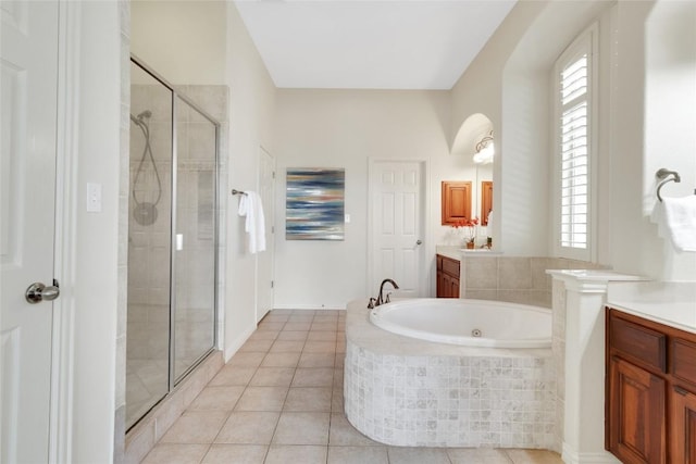 full bathroom featuring a shower stall, vanity, a bath, and plenty of natural light