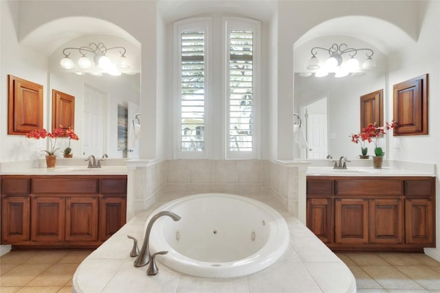 full bath featuring a tub with jets, two vanities, and tile patterned flooring