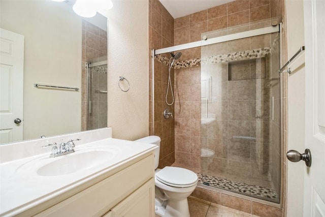full bath featuring a stall shower, toilet, vanity, and tile patterned flooring