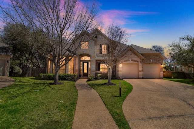 french country inspired facade featuring concrete driveway, an attached garage, brick siding, and stone siding