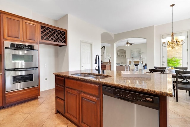 4004 Buckhaven Cv, Cedar Park, TX 78613 - kitchen with stainless steel appliances, a sink, arched walkways, stone counters, and a ceiling fan