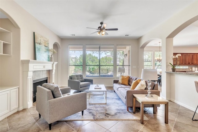4004 Buckhaven Cv, Cedar Park, TX 78613 - living room featuring a ceiling fan, a tile fireplace, and arched walkways