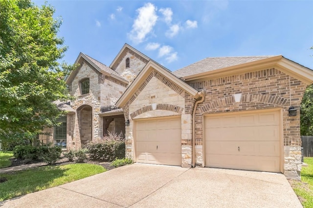 4004 Buckhaven Cv, Cedar Park, TX 78613 - french country style house with stone siding, concrete driveway, an attached garage, and brick siding