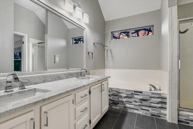6032 Abilene Trl, Austin, TX 78749 - full bath with a stall shower, vaulted ceiling, tile patterned floors, double vanity, and a garden tub