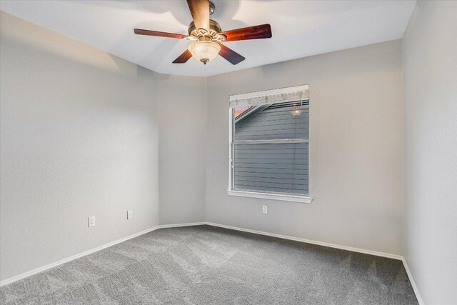 spare room with baseboards, ceiling fan, and carpet